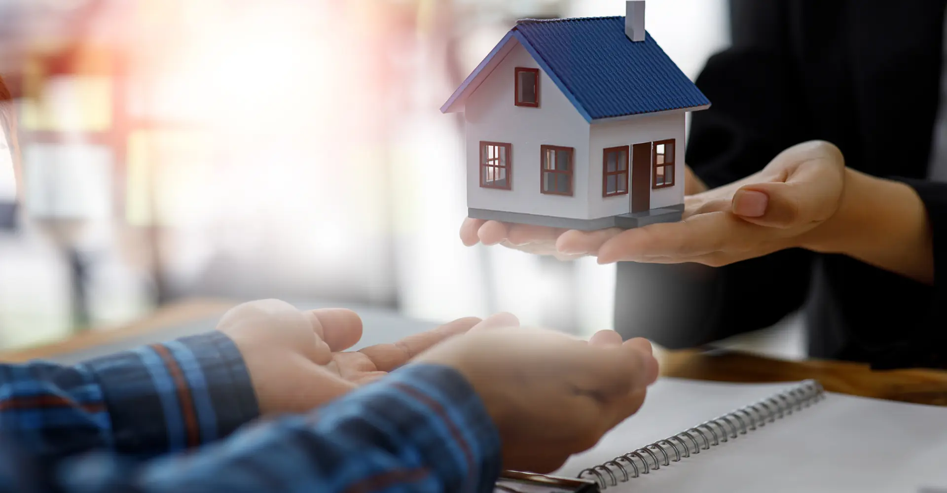 Maquete de casa sendo entregue em mãos durante a negociação do imóvel